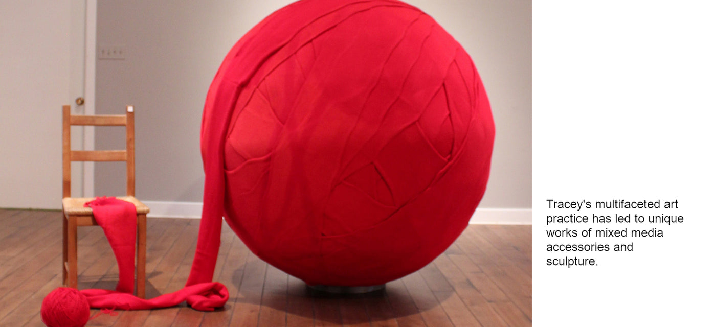 Ruby red six foot knitted yarn ball by Tracey Martin sitting in an art gallery.